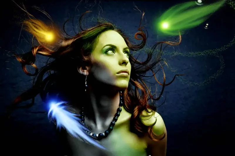a woman in the dark surrounded by colourful flying orbs