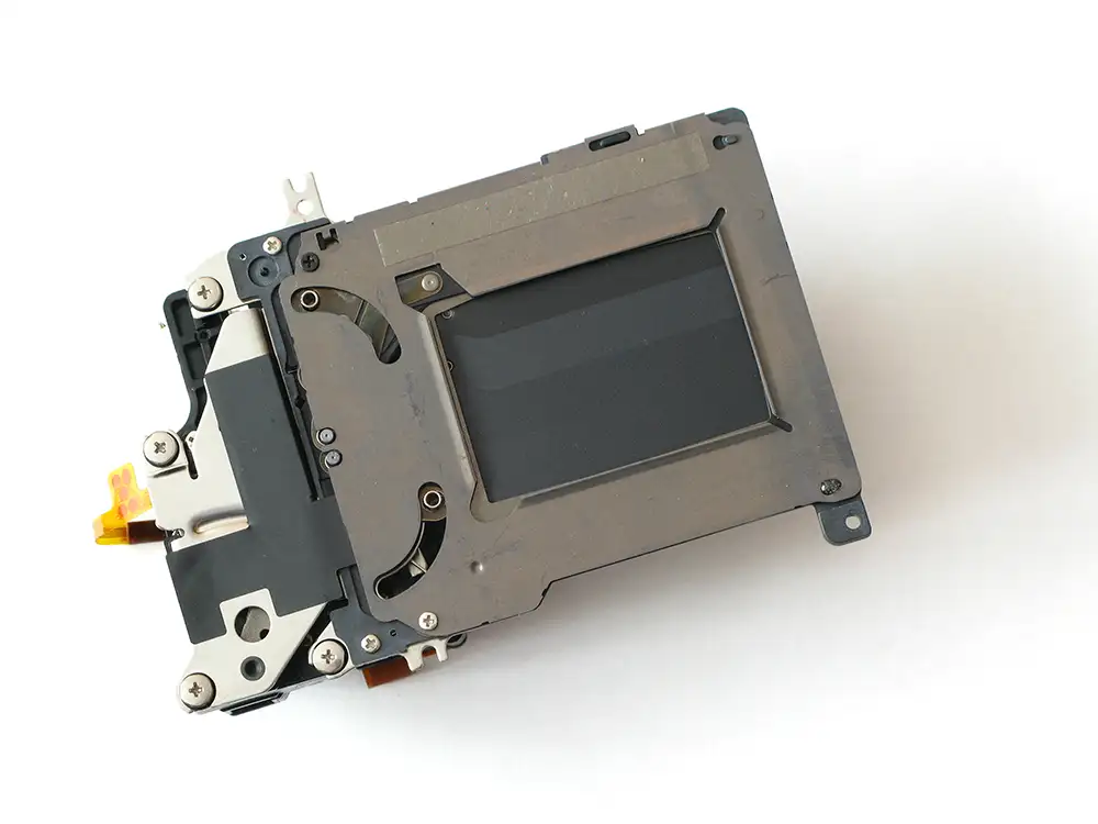 A dismantled shutter unit from a digital camera